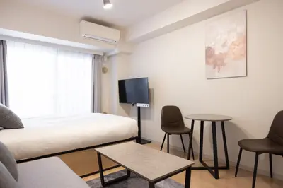 a bedroom with a bed and a tv and a table at \u30ec\u30b8\u30c7\u30a3\u30a2\u4e2d\u843d\u5408b in Tokyo