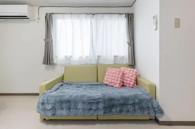 a bedroom with a bed with a blue blanket and a window at \u65b0\u4e0a\u91ce202 \u7ad9\u6b65\u884c7\u5206\u949f\u7a3b\u6210\u753a\u7ad92\u5206\u949f in Tokyo