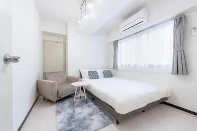 a bedroom with a bed and a chair and a window at \u65b0\u4e0a\u91ce202 \u7ad9\u6b65\u884c7\u5206\u949f\u7a3b\u6210\u753a\u7ad92\u5206\u949f in Tokyo