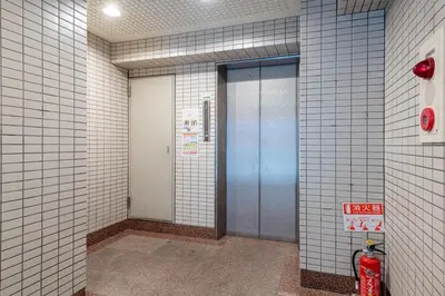 a hallway with two elevators and a blue door at \u4e0a\u91ce402 MAX 8 \u9280\u5ea7Asakusa\u30a8\u30ea\u30a2Wi - Fi in Tokyo