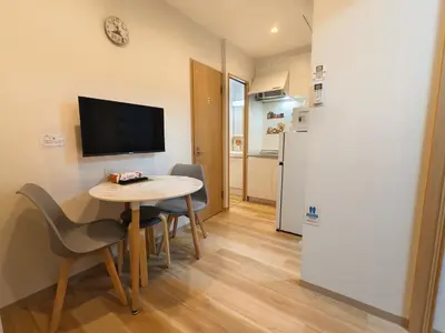 a small room with a table and chairs and a television at Issyuku Hotel Kotobuki Sanchome in Tokyo