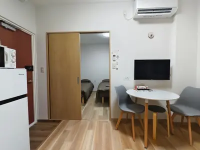 a small room with a table and chairs and a television at Issyuku Hotel Kotobuki Sanchome in Tokyo