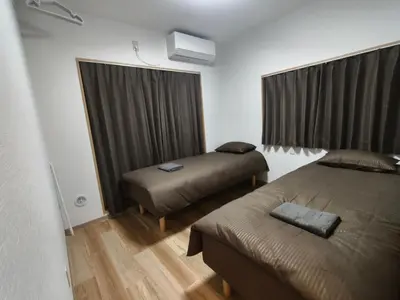 a hotel room with two beds and a window at Issyuku Hotel Kotobuki Sanchome in Tokyo