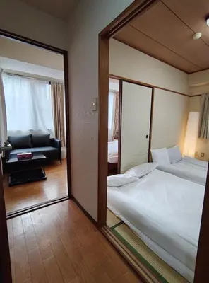 a mirror reflection of a bedroom with a bed and a couch at YKO Guest house in Akihabara 60 square meters, 3 bedrooms, 1 living rooms elevator, sky tree view in Tokyo