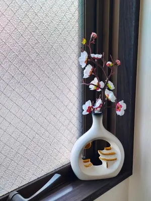 a white vase with flowers in it sitting on a window at YKO Guest house in Akihabara 60 square meters, 3 bedrooms, 1 living rooms elevator, sky tree view in Tokyo