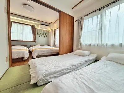 a room with three beds and a window at \u6effJR Soubusen Hirai 5mins walk Guest house! 2LDK,Max 8PP! Direct access to Kinshicyo,Akihabara,Shinjyuku! in Tokyo