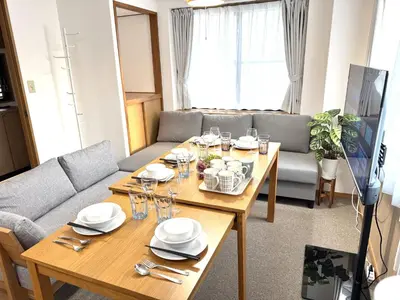 a living room with two tables and a couch at \u6effJR Soubusen Hirai 5mins walk Guest house! 2LDK,Max 8PP! Direct access to Kinshicyo,Akihabara,Shinjyuku! in Tokyo