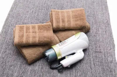 a hair dryer sitting next to a pile of towels at Shinjuku sprem in Tokyo