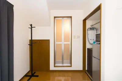 a hallway with a wooden door and a mirror at Shinjuku sprem in Tokyo