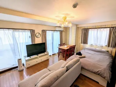 a bedroom with a couch and a television and a table at Shinjuku sprem in Tokyo
