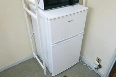 a white refrigerator with a microwave on top of it at \u6b63\u6804\u30cf\u30a4\u30c4101 in Tokyo