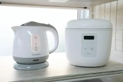 a white appliance sitting on a counter next to a blender at \u6b63\u6804\u30cf\u30a4\u30c4101 in Tokyo