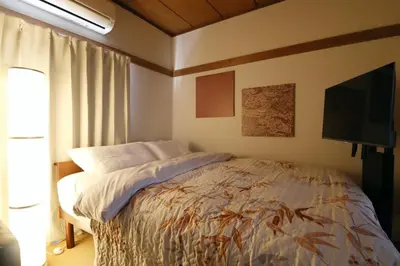 a bedroom with a bed and a flat screen tv at \u6b63\u6804\u30cf\u30a4\u30c4202 in Tokyo