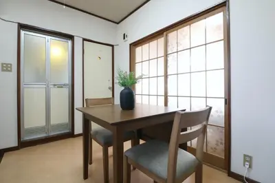 a dining room with a table and chairs with a vase on it at \u6b63\u6804\u30cf\u30a4\u30c4202 in Tokyo