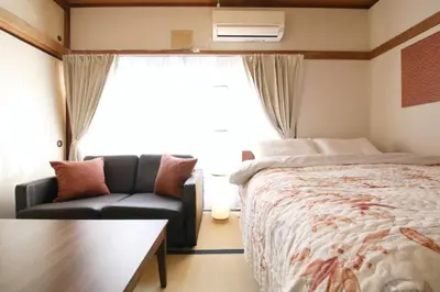 a bedroom with a bed and a couch and a window at \u6b63\u6804\u30cf\u30a4\u30c4202 in Tokyo