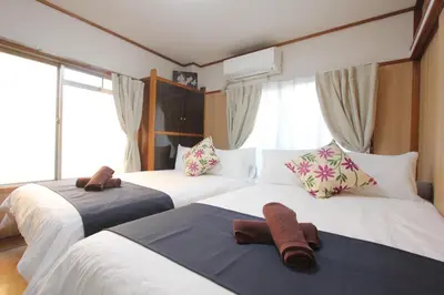 a bedroom with two beds with towels on them at Hotel LUANA in Shin-Nakano in Tokyo
