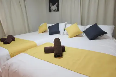 a group of three beds with slippers on them at Hotel LUANA in Shin-Nakano in Tokyo