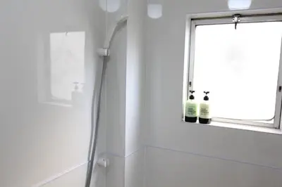 a bathroom with a shower and two bottles of wine at Hotel LUANA in Shin-Nakano in Tokyo