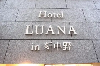 a sign for the hotel lzuota on the side of a building at Hotel LUANA in Shin-Nakano in Tokyo