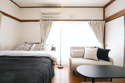 a bedroom with a bed and a couch and a table at \u6b63\u6804\u30cf\u30a4\u30c4201 in Tokyo