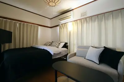 a room with a couch and a bed and a table at \u6b63\u6804\u30cf\u30a4\u30c4201 in Tokyo