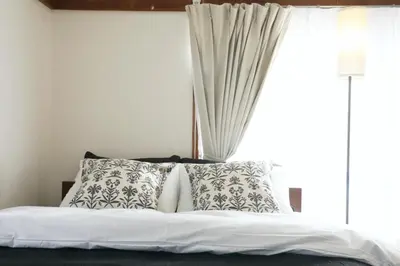 a bed with white sheets and pillows in front of a window at \u6b63\u6804\u30cf\u30a4\u30c4201 in Tokyo