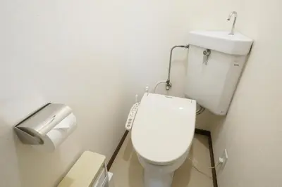 a white toilet in a bathroom with a toilet paper dispenser at \u6b63\u6804\u30cf\u30a4\u30c4201 in Tokyo