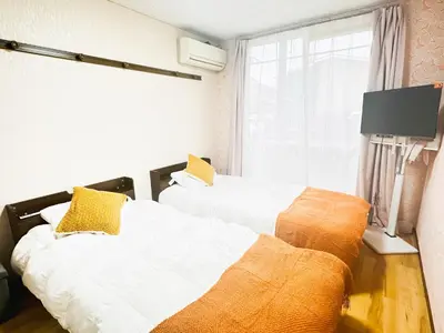 two beds sitting next to each other in a room at \u96c0\u8272\u65b9\u5357 \u65b0\u5bbf\u99c5\u307e\u306714\u5206 \u6771\u4eac\u99c5\u307e\u306730\u5206 \u65b9\u5357\u753a\u5f92\u6b698\u5206 \u5bdd\u5ba4\u4e8c\u3064 \u6700\u59274\u4eba \u6d17\u6fef\u6a5f \u30ad\u30c3\u30c1\u30f3 \u96fb\u5b50\u30ec\u30f3\u30b8 in Tokyo