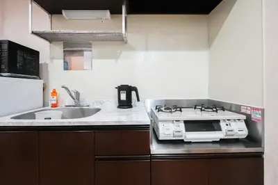 a kitchen with a stove and a sink at \u96c0\u8272\u65b9\u5357 \u65b0\u5bbf\u99c5\u307e\u306714\u5206 \u6771\u4eac\u99c5\u307e\u306730\u5206 \u65b9\u5357\u753a\u5f92\u6b698\u5206 \u5bdd\u5ba4\u4e8c\u3064 \u6700\u59274\u4eba \u6d17\u6fef\u6a5f \u30ad\u30c3\u30c1\u30f3 \u96fb\u5b50\u30ec\u30f3\u30b8 in Tokyo