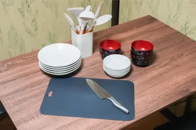 a table with plates and a knife on a cutting board at \u96c0\u8272\u65b9\u5357 \u65b0\u5bbf\u99c5\u307e\u306714\u5206 \u6771\u4eac\u99c5\u307e\u306730\u5206 \u65b9\u5357\u753a\u5f92\u6b698\u5206 \u5bdd\u5ba4\u4e8c\u3064 \u6700\u59274\u4eba \u6d17\u6fef\u6a5f \u30ad\u30c3\u30c1\u30f3 \u96fb\u5b50\u30ec\u30f3\u30b8 in Tokyo
