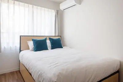 a bedroom with a large bed with blue pillows at \u97f3\u7fbds\u30b0\u30ec\u30fc\u30b9 in Tokyo