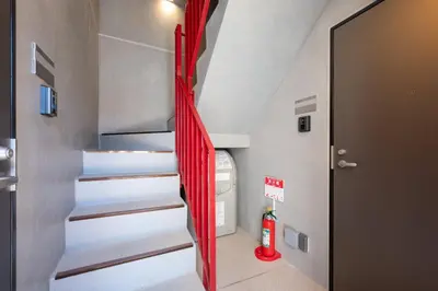a staircase in a tiny house with red ribbon at \u97f3\u7fbds\u30b0\u30ec\u30fc\u30b9 in Tokyo