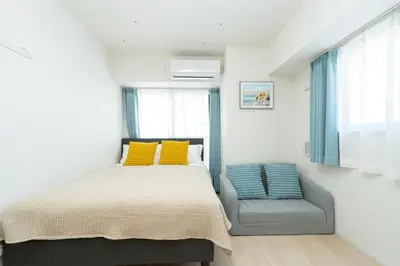 a bedroom with a bed and a chair at KINSHICHO Tokyo Holiday Hotel in Tokyo