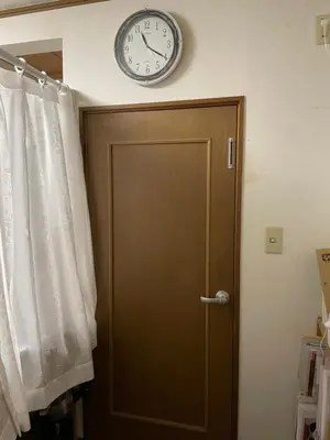 a clock on the wall above a door at Homestay at M's House Not entire property just one room in Tokyo