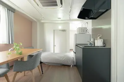 a kitchen with a table and a bed in a room at unito residence TSUKIJI in Tokyo