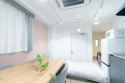a kitchen and dining room with a table and a refrigerator at unito residence TSUKIJI in Tokyo