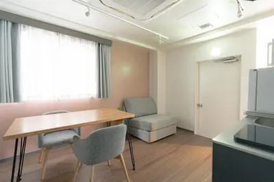 a room with a table and chairs and a television at unito residence TSUKIJI in Tokyo