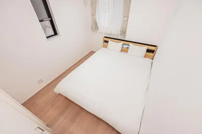 a bed in a room with white walls and wooden floors at Japan House Skytree \u30f4\u30a3\u30e9\u8cb8\u5207 B\u9928 in Tokyo