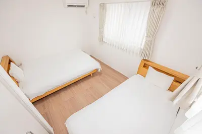 a small bedroom with two beds and a window at Japan House Skytree \u30f4\u30a3\u30e9\u8cb8\u5207 B\u9928 in Tokyo