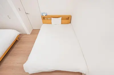 a bed in a room with a white bedsheet at Japan House Skytree \u30f4\u30a3\u30e9\u8cb8\u5207 B\u9928 in Tokyo