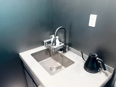 a sink in a bathroom with a black wall at Ikebukuro\u6b63\u548c\u5eb5 in Tokyo