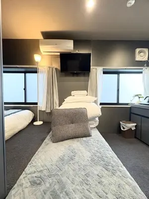 a hotel room with two beds and a chair at Ikebukuro\u6b63\u548c\u5eb5 in Tokyo