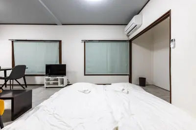 a bedroom with a large white bed and a tv at M-stay Nishi-shinjuku in Tokyo