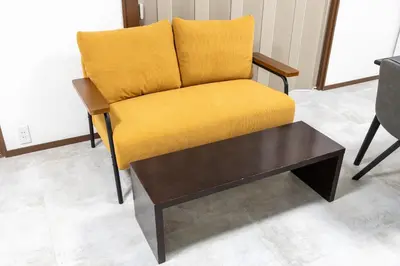 a yellow chair and a coffee table in a room at M-stay Nishi-shinjuku in Tokyo