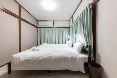 a bedroom with a large white bed and a window at M-stay Nishi-shinjuku in Tokyo