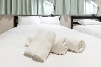 a bed with two white towels on it at M-stay Nishi-shinjuku in Tokyo