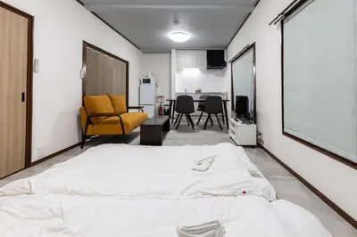 a bedroom with a large bed and a living room at M-stay Nishi-shinjuku in Tokyo
