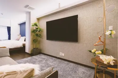 a living room with a flat screen tv on a wall at \u90fd\u5fc3\u7f55\u89c1 \u79cb\u53f6\u539f\u4e1c\u4eac\u7ad9KCoa \u8d85\u7ea7\u5962\u534e\u53cc\u5367\u5957\u623f\u5e26\u53a8\u623f \u5730\u94c13\u5206\u949f \u6234\u68eePOLA\u9876\u7ea7\u914d\u7f6e \u79cb\u53f6\u539f\u6b65\u884c\u53ef\u8fbe \u4e1c\u4eac\u7ad94\u5206\u949f in Tokyo