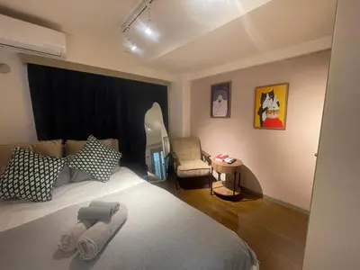 a bedroom with a bed with a chair and a table at Ichigaya Stay & Wi-Fi 1 in Tokyo