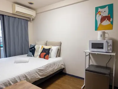 a small bedroom with a bed with a tv on it at Ichigaya Stay & Wi-Fi 1 in Tokyo